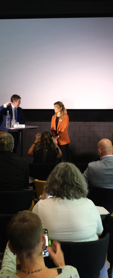 Ein Saal voller Leute und ganz vorne Bundesrat Rösti und Greta Gysin